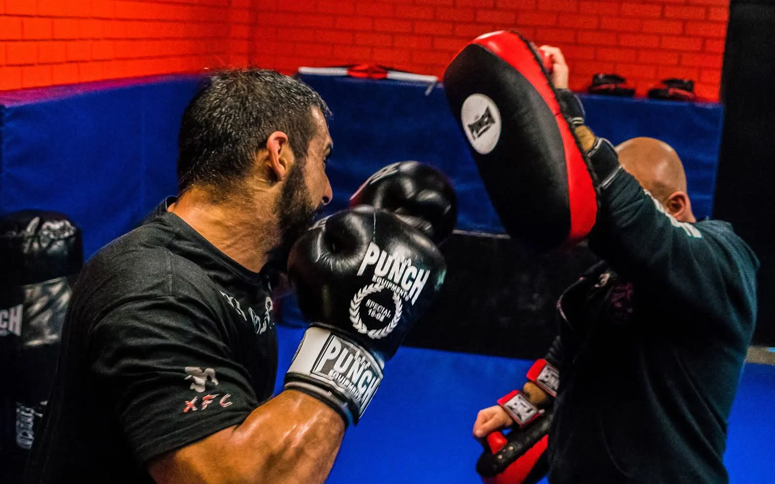 A right hand landing on the focus mitt during pad work with a coach